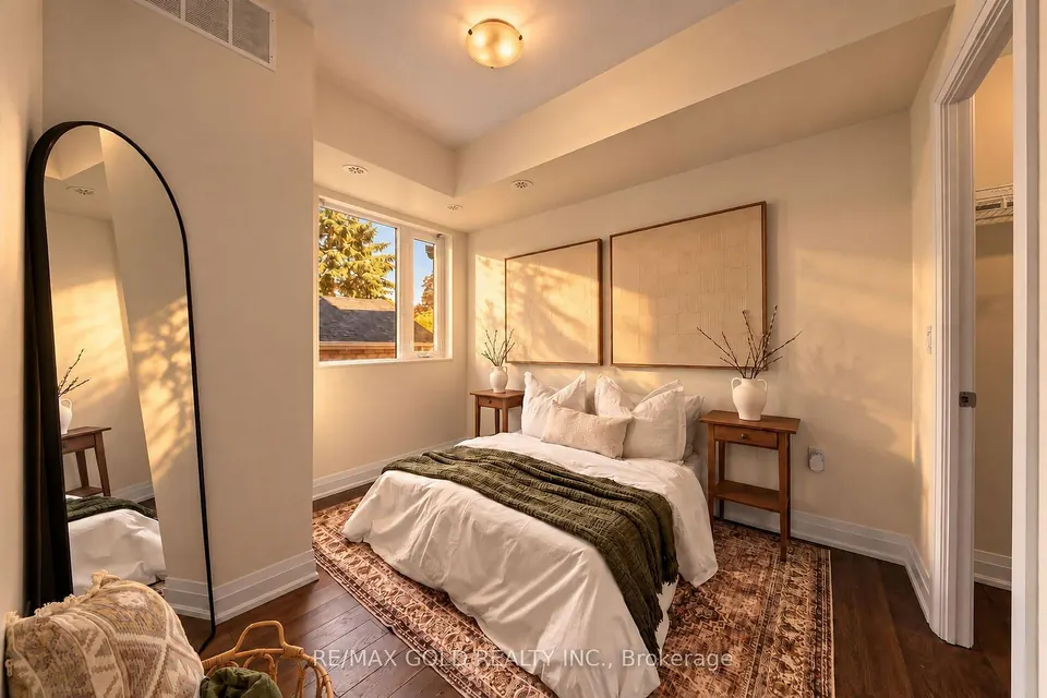 Bedroom with a tall mirror and warm wood accents