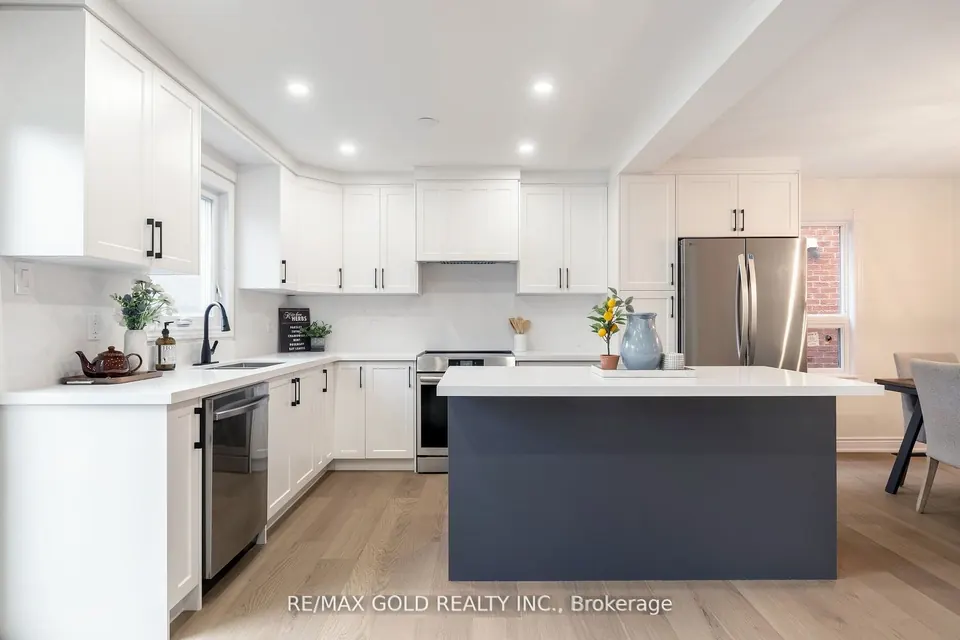 White kitchen with a dark island and stainless appliances
