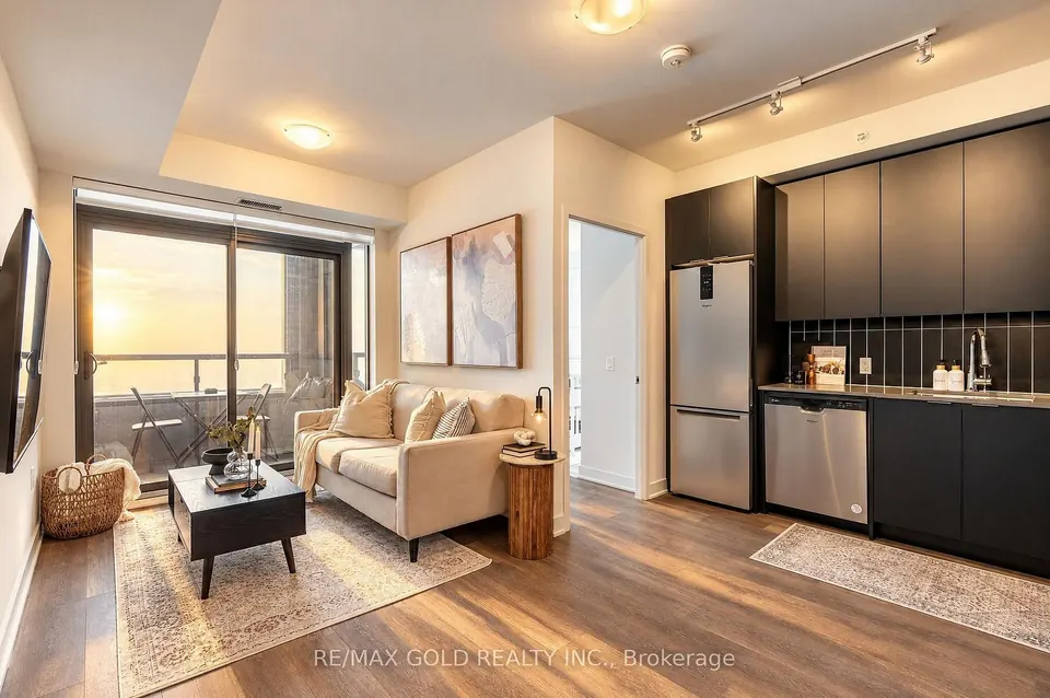 Condo living room and dark kitchen beside the balcony door