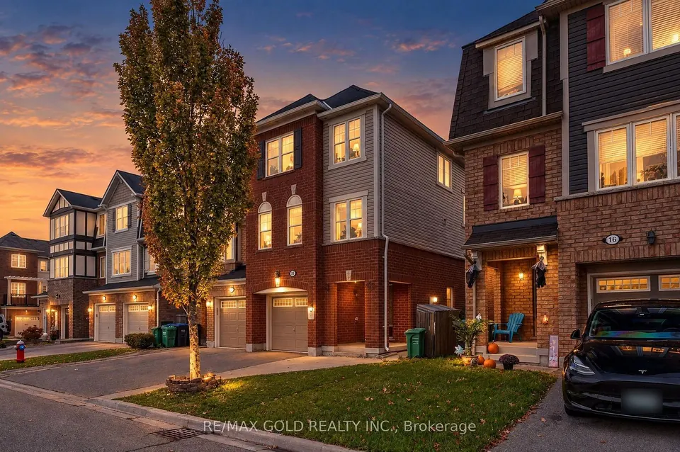 Townhome entrance at dusk with a tall tree out front