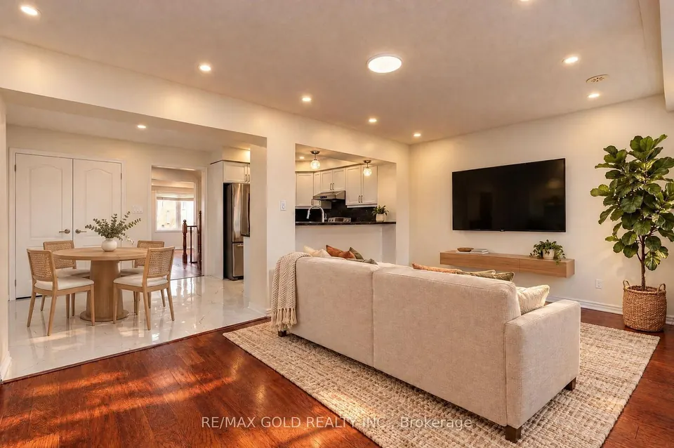 Living and dining room with a cream sofa and hardwood floors