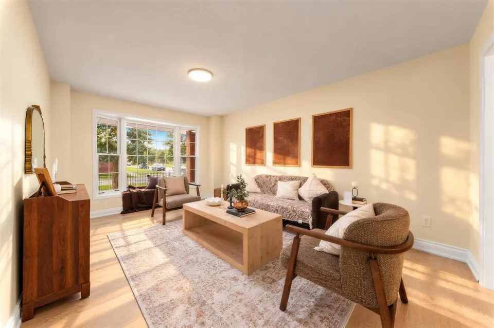 Sunlit living room with armchairs, a wool rug and a low wood coffee table