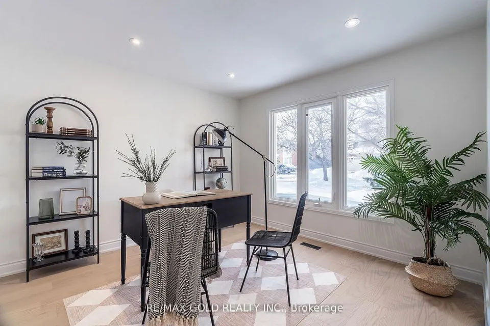 Home office with arched shelving, a desk and a tall plant