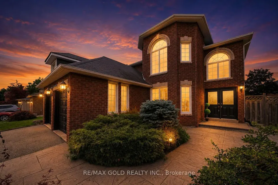 Front walk and garden of a brick home at dusk